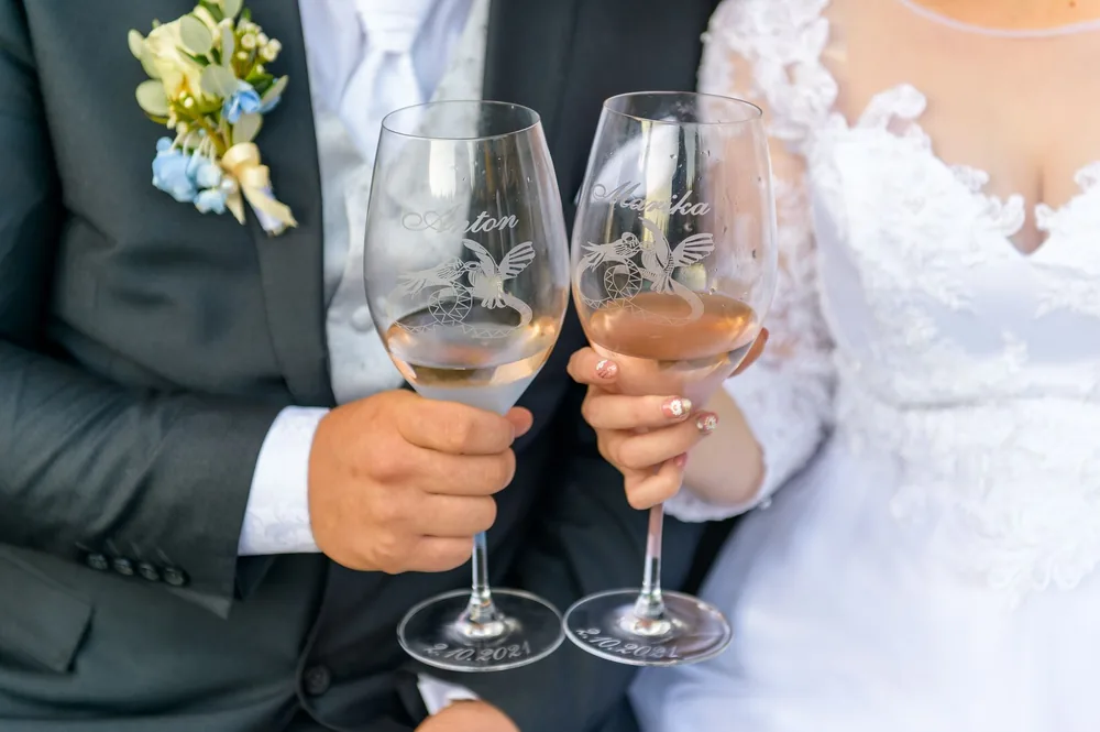 A bride and groom toasting with wineglasses at their wedding celebration