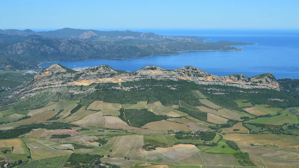 A coastal mountain range and lush countryside fields
