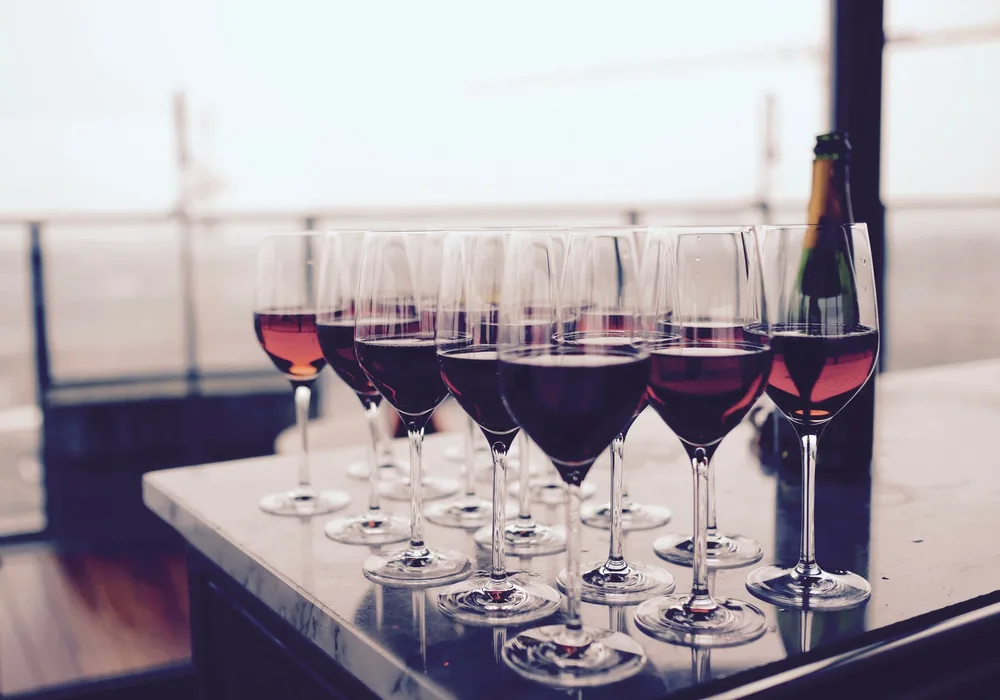 A collection of red wine glasses elegantly arranged on a bar table, perfect for events