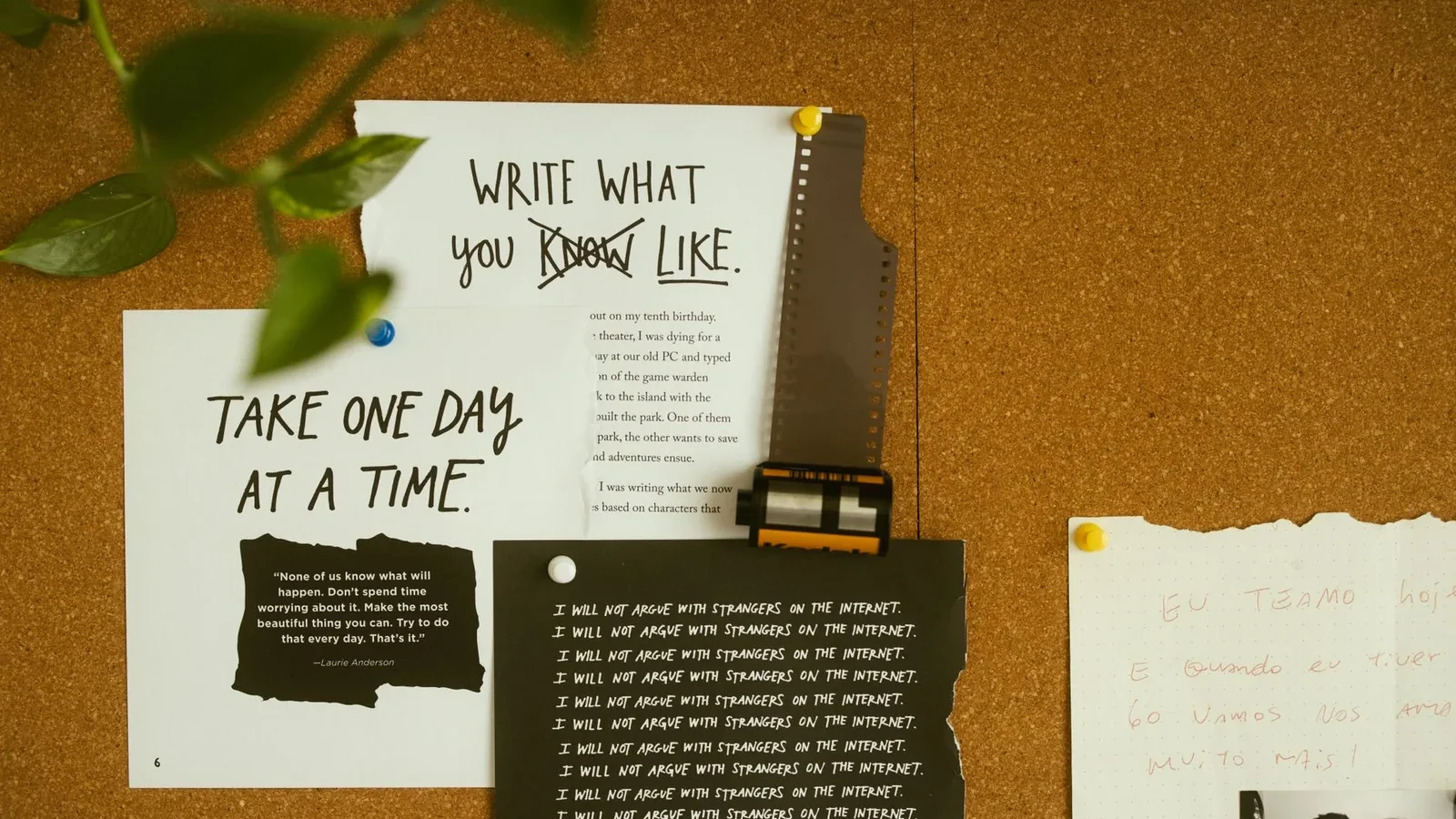 A corkboard with motivational quotes, notes, and film negatives, fostering creativity and reflection