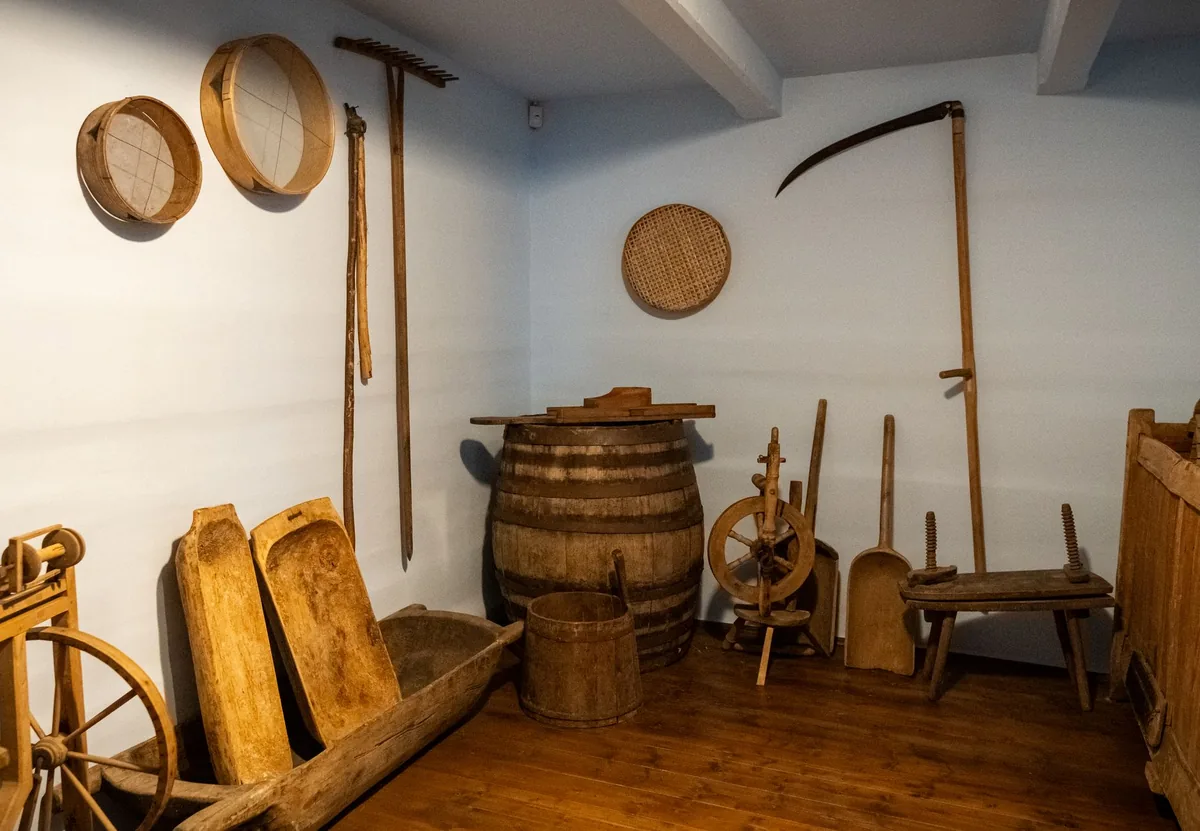 A display of vintage wooden tools and barrels in a historical museum setting