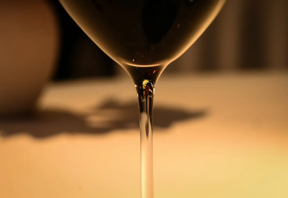 A glass of red wine is poured