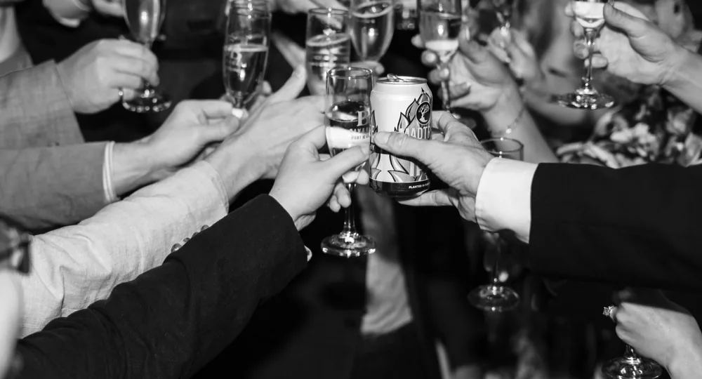 A group of adults clinking glasses in a lively black and white celebration