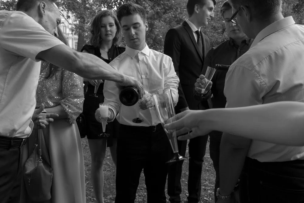 A group of adults enjoying an outdoor celebration with champagne glasses in hand