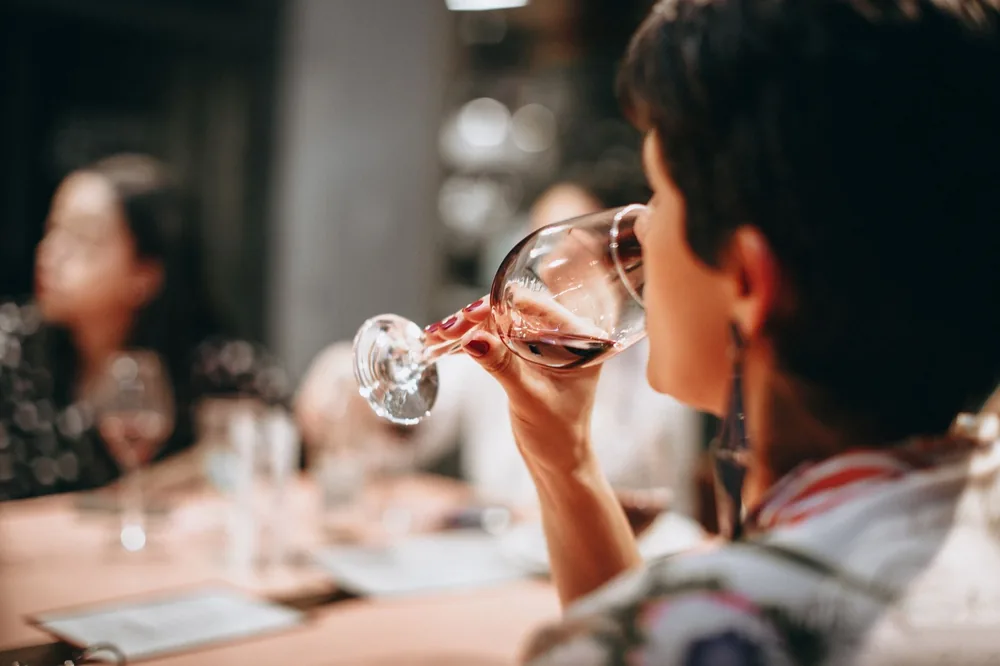 A group of adults enjoying wine together indoors in a warm social setting