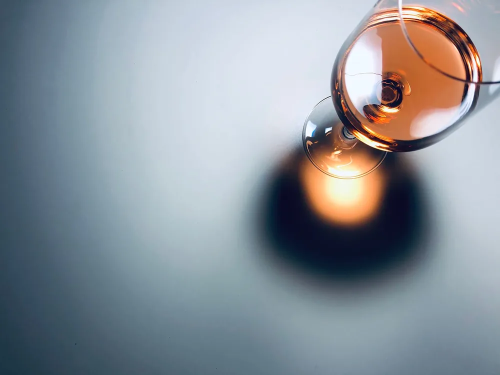 A half-full wine glass casting a shadow, perfect for beverage and lifestyle themes