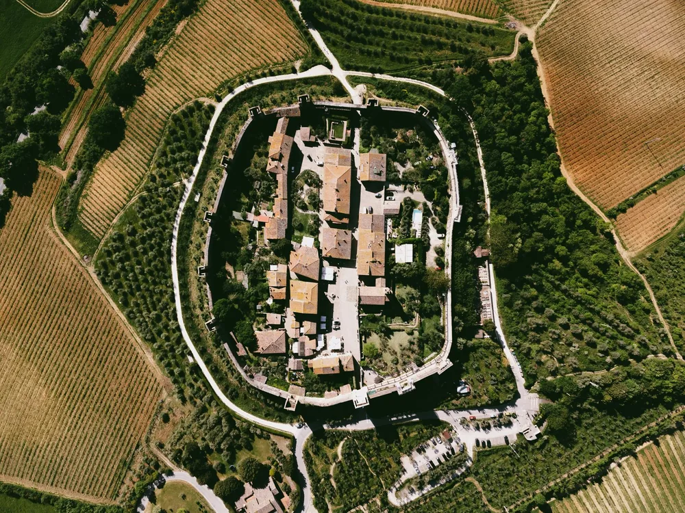 A historic circular fortified village surrounded by lush vineyards