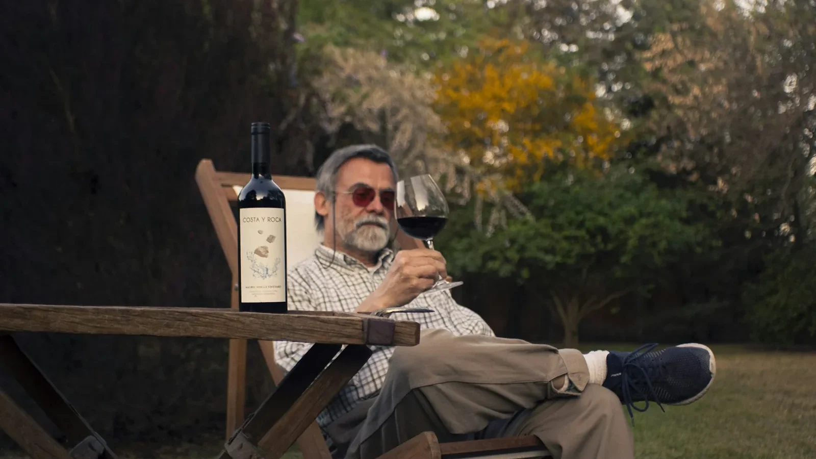 A man sitting in a chair holding a glass of wine
