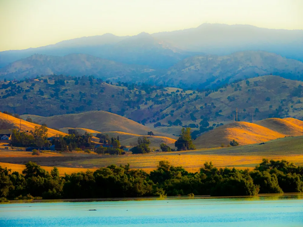 A mountain range with a lake in the foreground