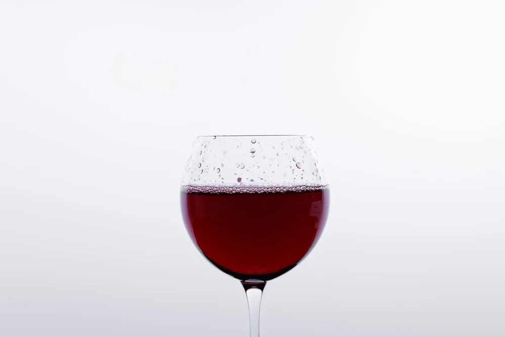 A red wine glass on a minimalist white background, ideal for beverage themes