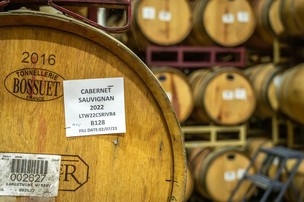 A rustic wine cellar filled with Cabernet Sauvignon barrels, showcasing vintage charm