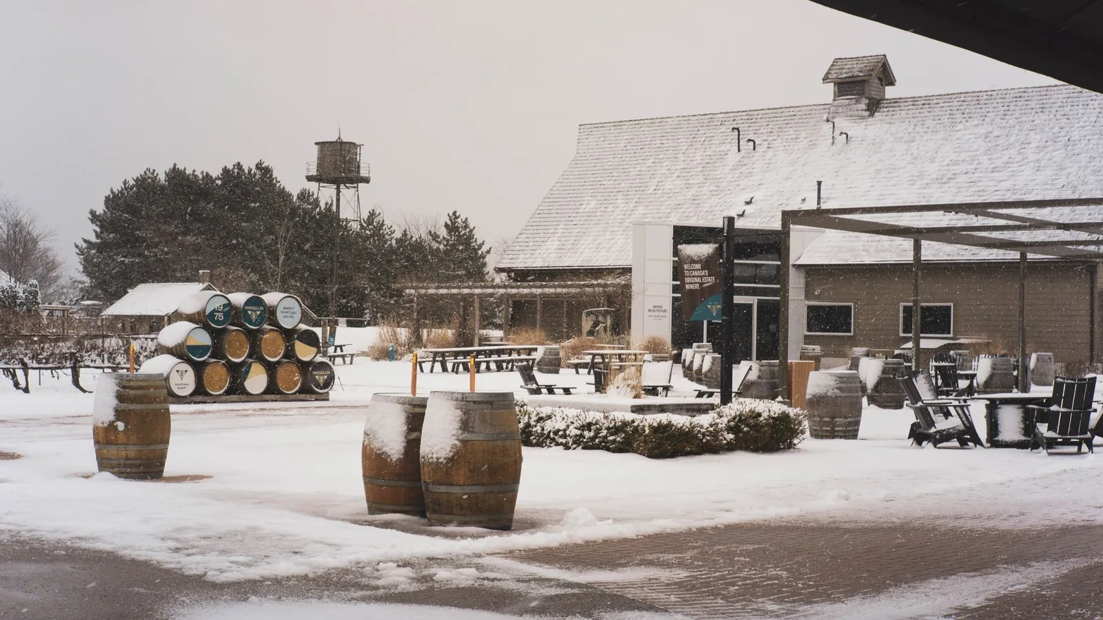 A snowy winter scene at a winery with barrels and outdoor seating