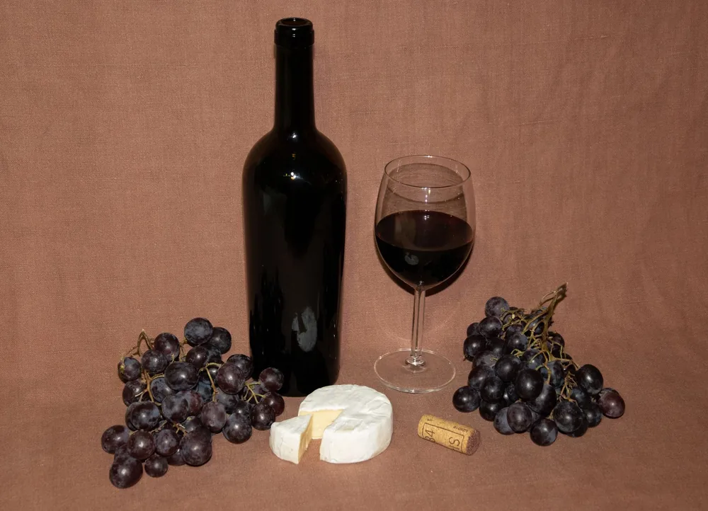 A sophisticated setup featuring wine, cheese, and grapes, ideal for culinary themes