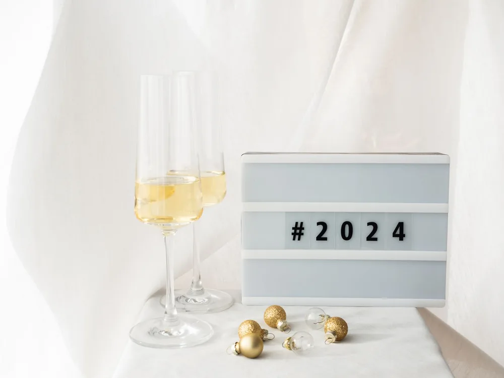 A stylish New Year setup featuring champagne glasses and golden baubles