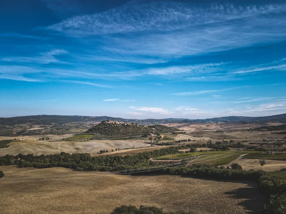 A vast, countryside landscape under a bright blue sky