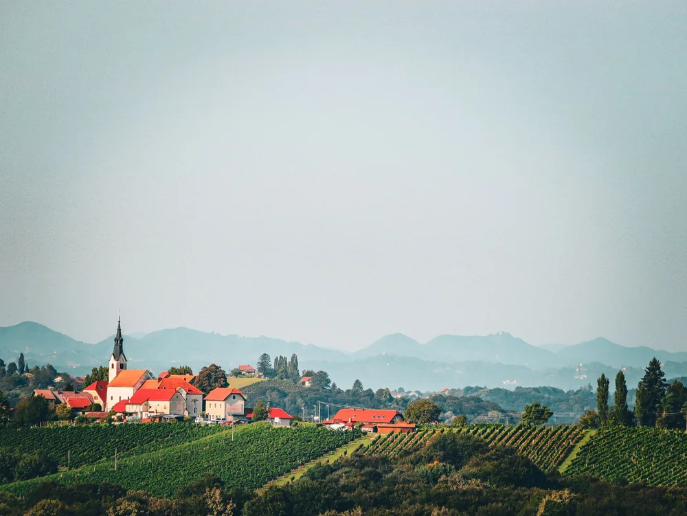 A village and vineyard set against rolling hills and mountains