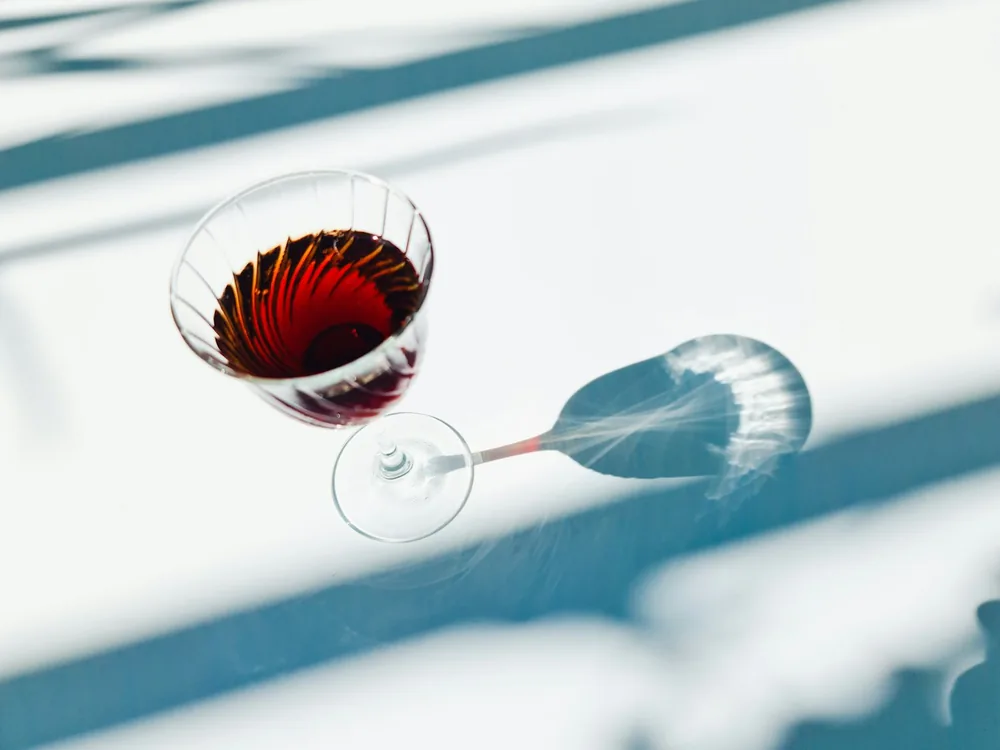 A wine glass with a red liquid in it
