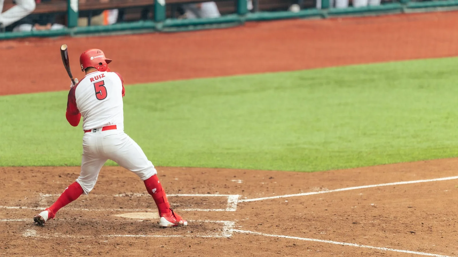 Action shot of a baseball player swinging a bat in a game with clear view of field