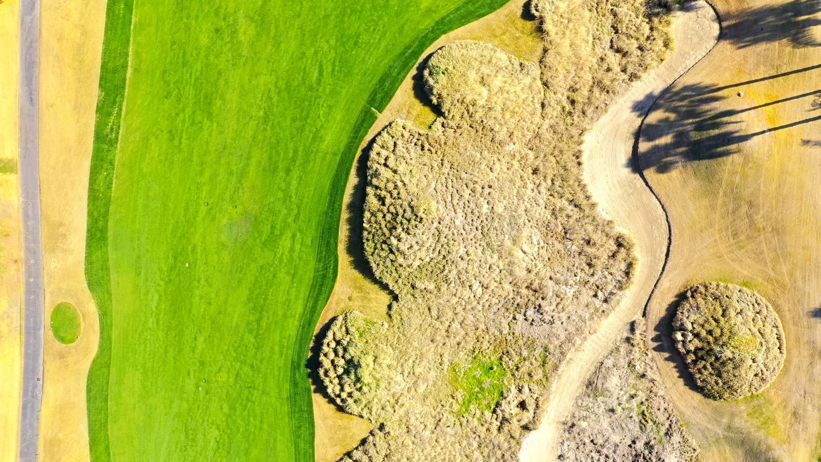 Aerial shot showcasing a lush golf course and arid landscape in La Quinta, California