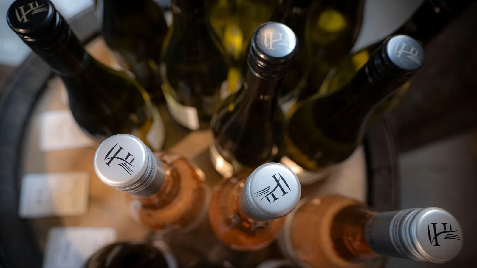 An artistic top view photo of various wine bottles arranged on a wooden table