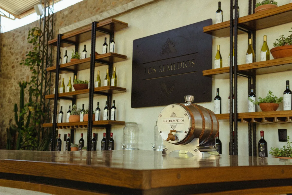 An elegant wine bar interior featuring a decorative barrel and neatly arranged wine bottles on shelves