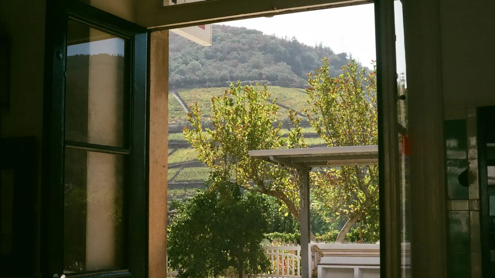 An open door leading to a patio with a table and bench
