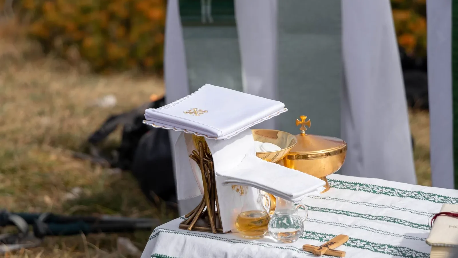 An outdoor altar setup for a religious ceremony with communion elements on a table