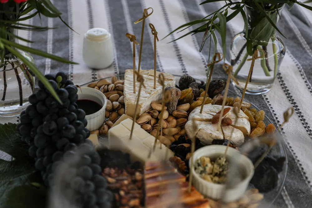 Assortment of cheeses with grapes and nuts on a table setting