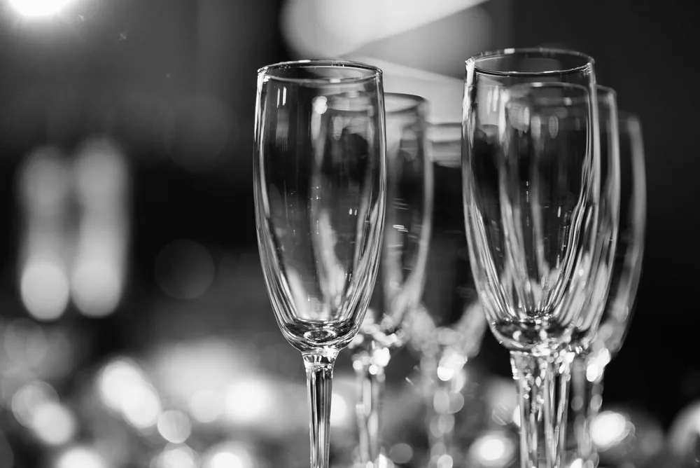 Black and white image of champagne glasses with a blurred bokeh background, perfect for elegant occasions
