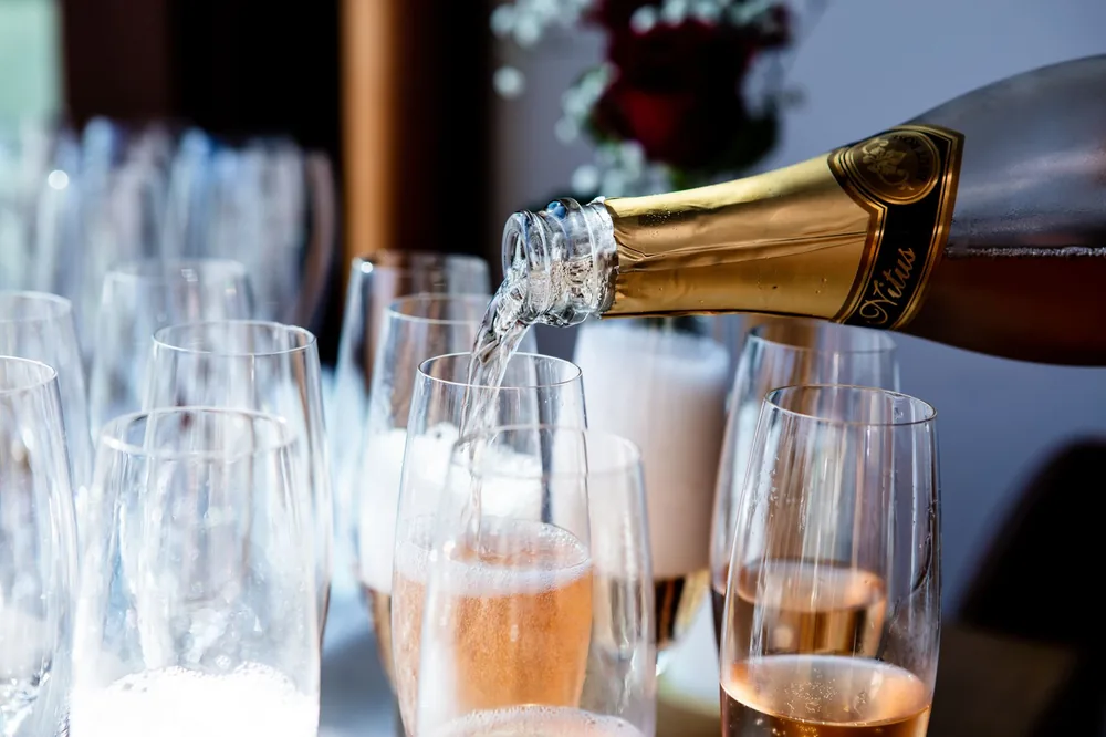 Champagne being poured into flute glasses at a celebration or event