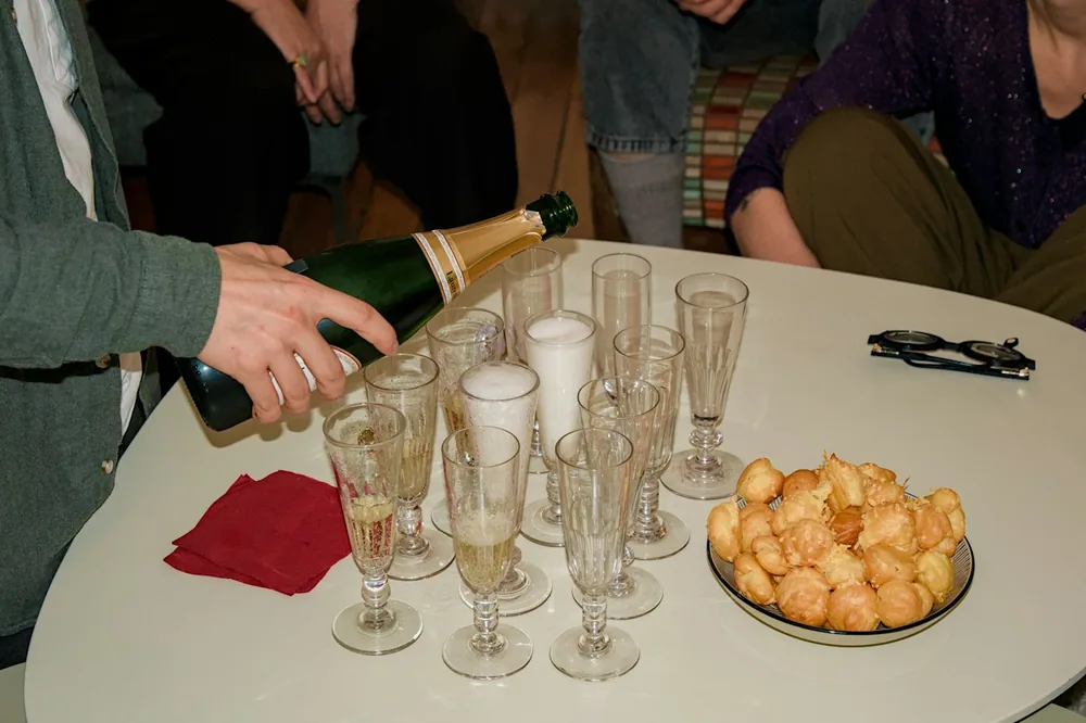 Champagne being poured into glasses with pastries