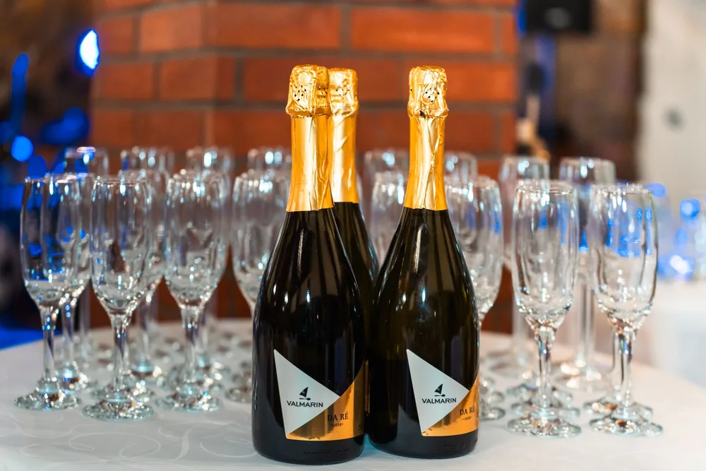 Champagne bottles with empty flutes on a table, set for a celebration or event