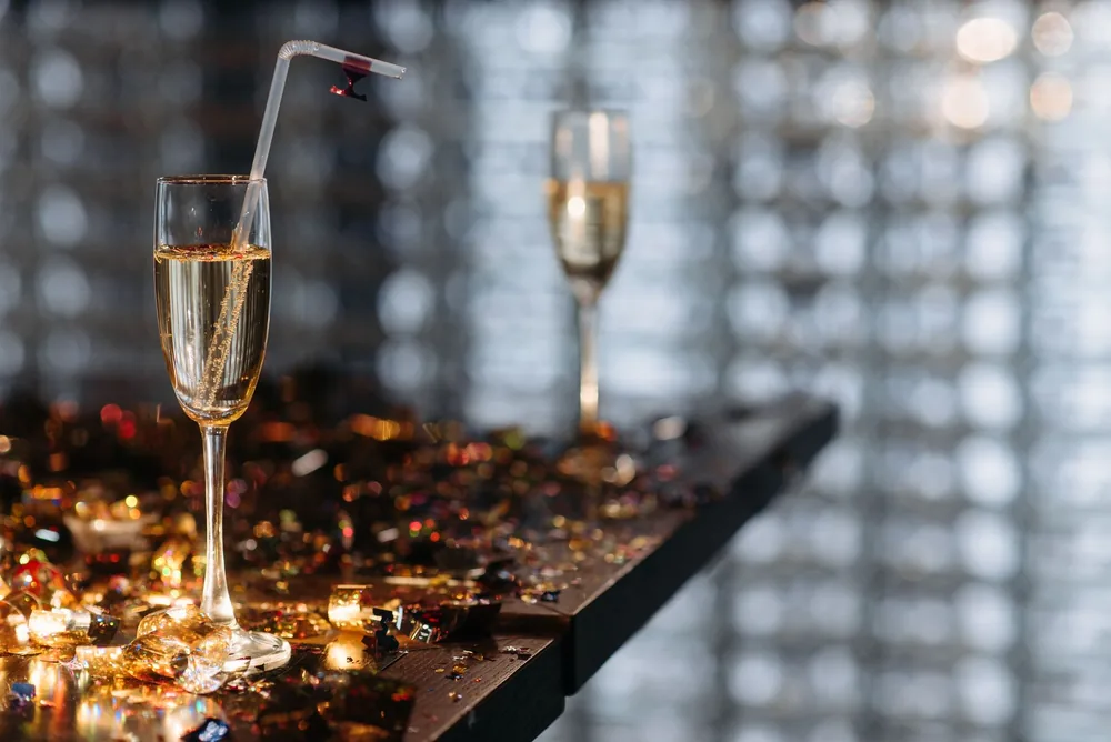 Champagne glasses on a table with festive confetti, creating a celebratory atmosphere
