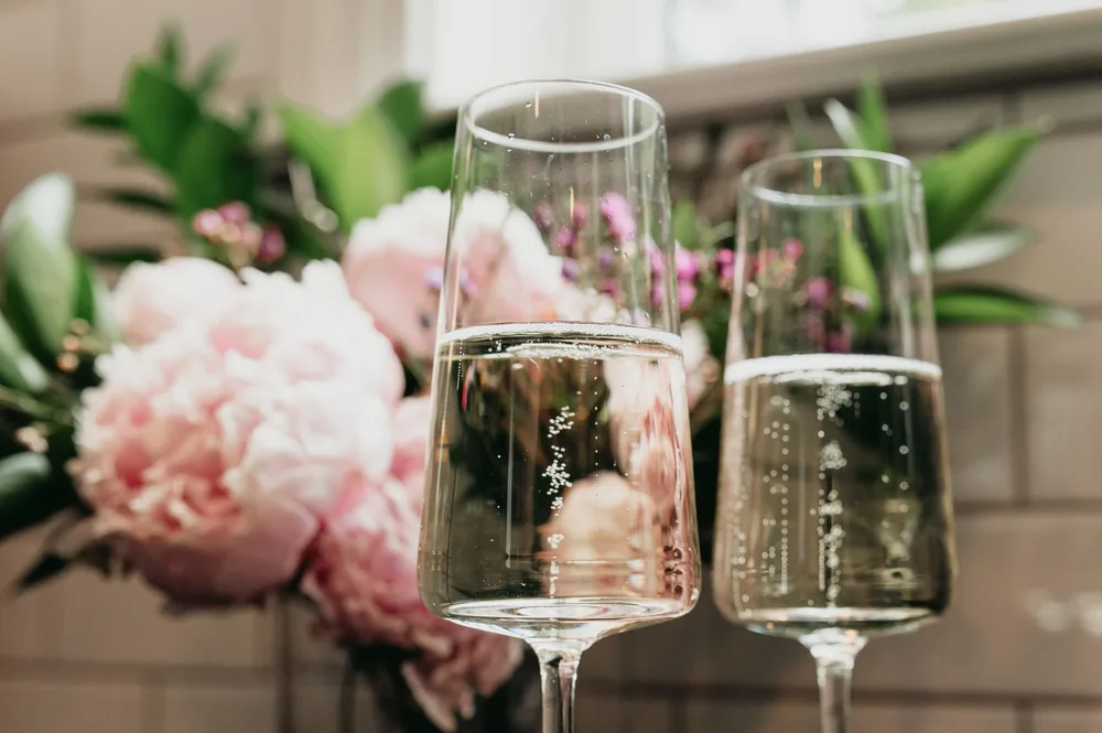 Champagne glasses with a soft focus floral background, creating a celebratory atmosphere