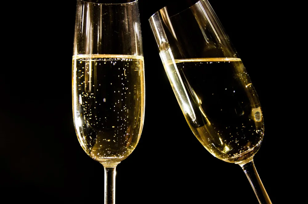 Champagne glasses with bubbles against a black background, perfect for celebrations