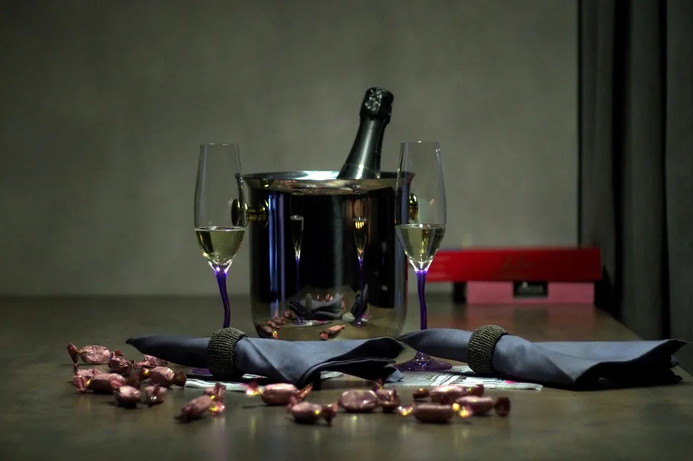 Champagne setup featuring glasses, a bottle on ice, and wrapped candies, ideal for celebratory events