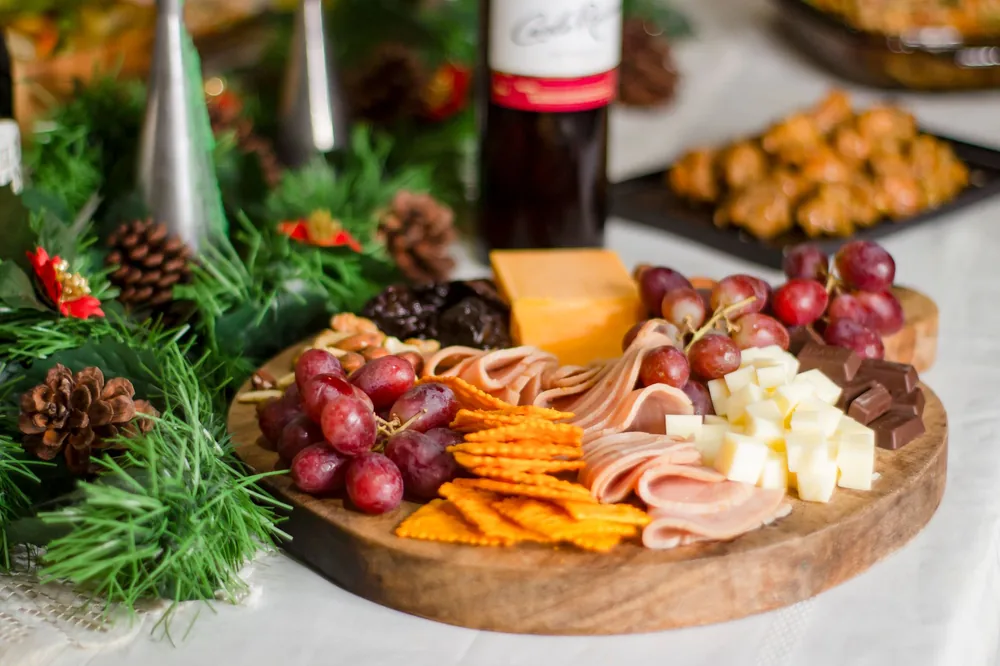 Charcuterie board with assorted cheese, meats, grapes, and crackers, perfect for festive gatherings