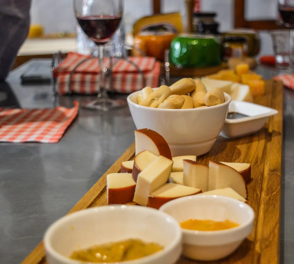 Cheese platter with wine and dips set on a wooden board, perfect for social gatherings