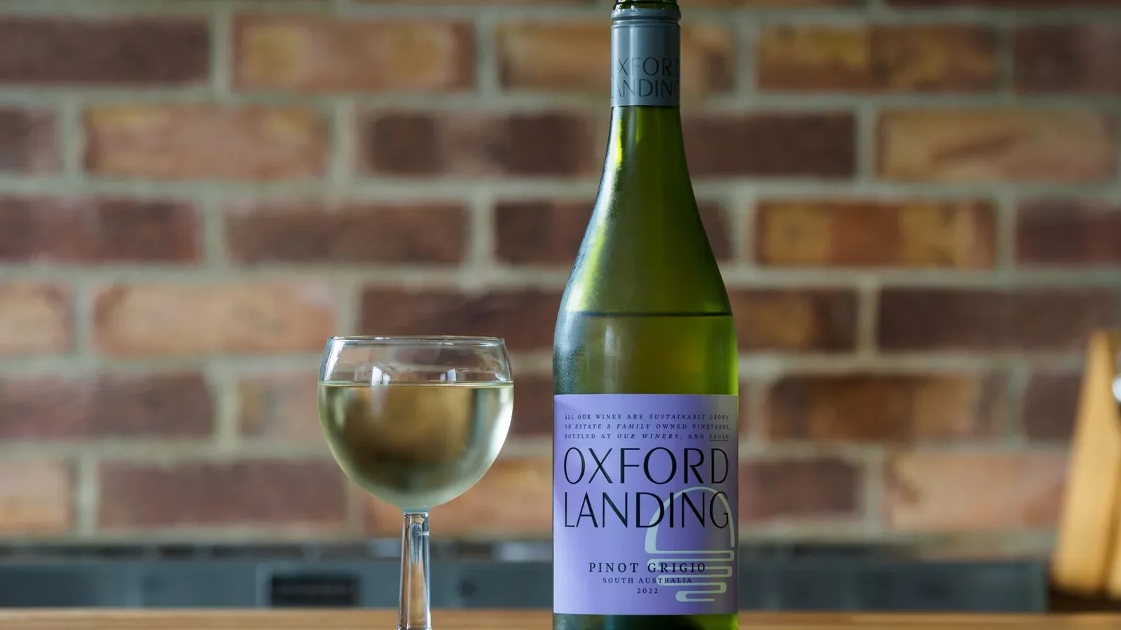 Chilled Oxford Landing Pinot Grigio against a rustic brick wall, perfect for wine enthusiasts