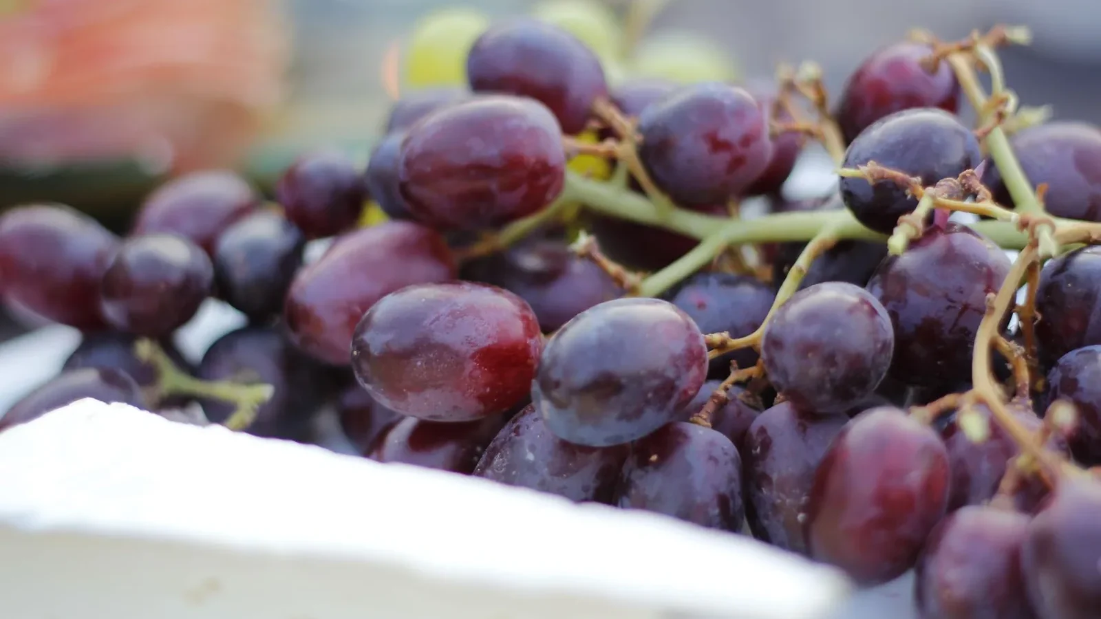 Close-up shot of fresh red grapes and cheese showcasing natural abundance and colors