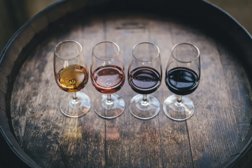 Four wines poured side by side on the head of an oak barrel