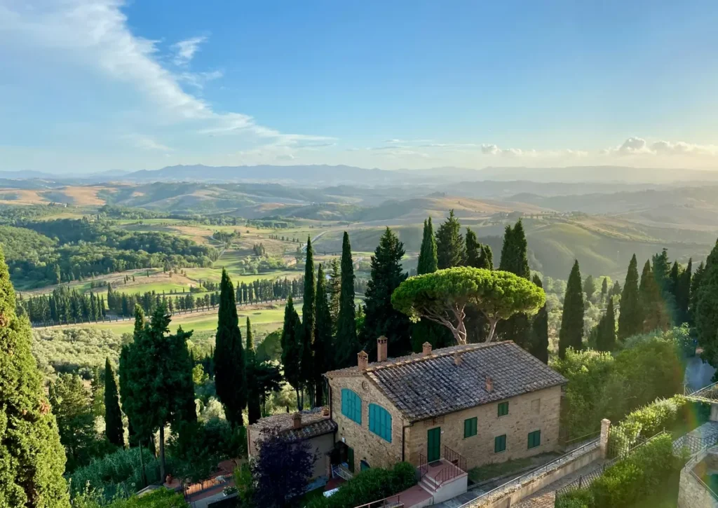 A stone estate framed by cypresses above an Italian valley