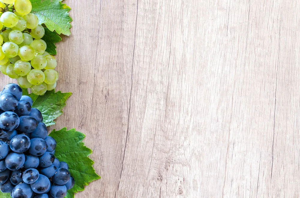 Colorful grapes on a wooden board, perfect for fresh food concepts