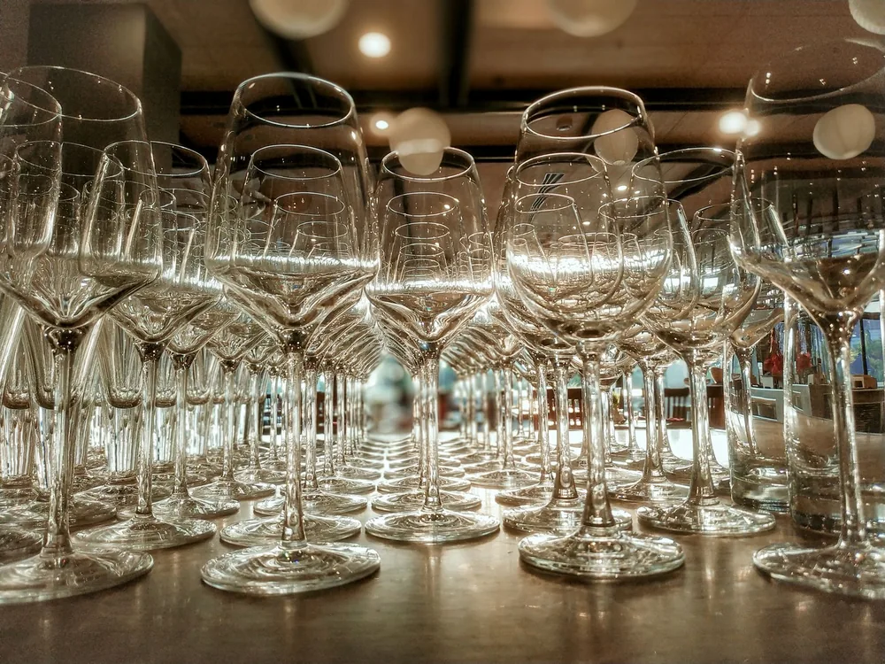 Crystal-clear wine glasses beautifully arranged on a restaurant table, reflecting elegance and sophistication