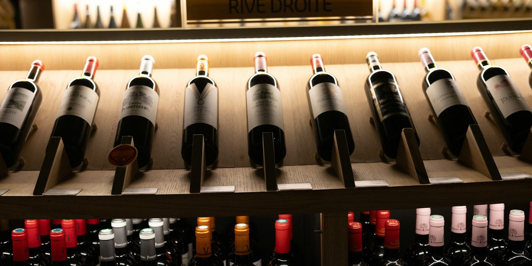 Wine bottles lined up on a shelf