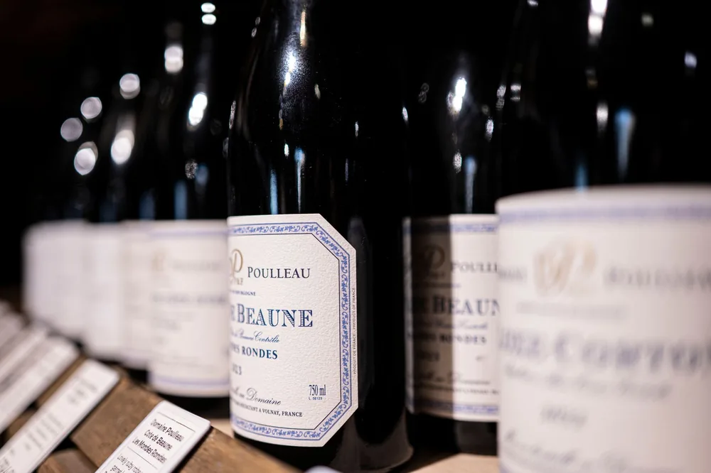 Detailed view of vintage wine bottles arranged on a store shelf, emphasizing luxury
