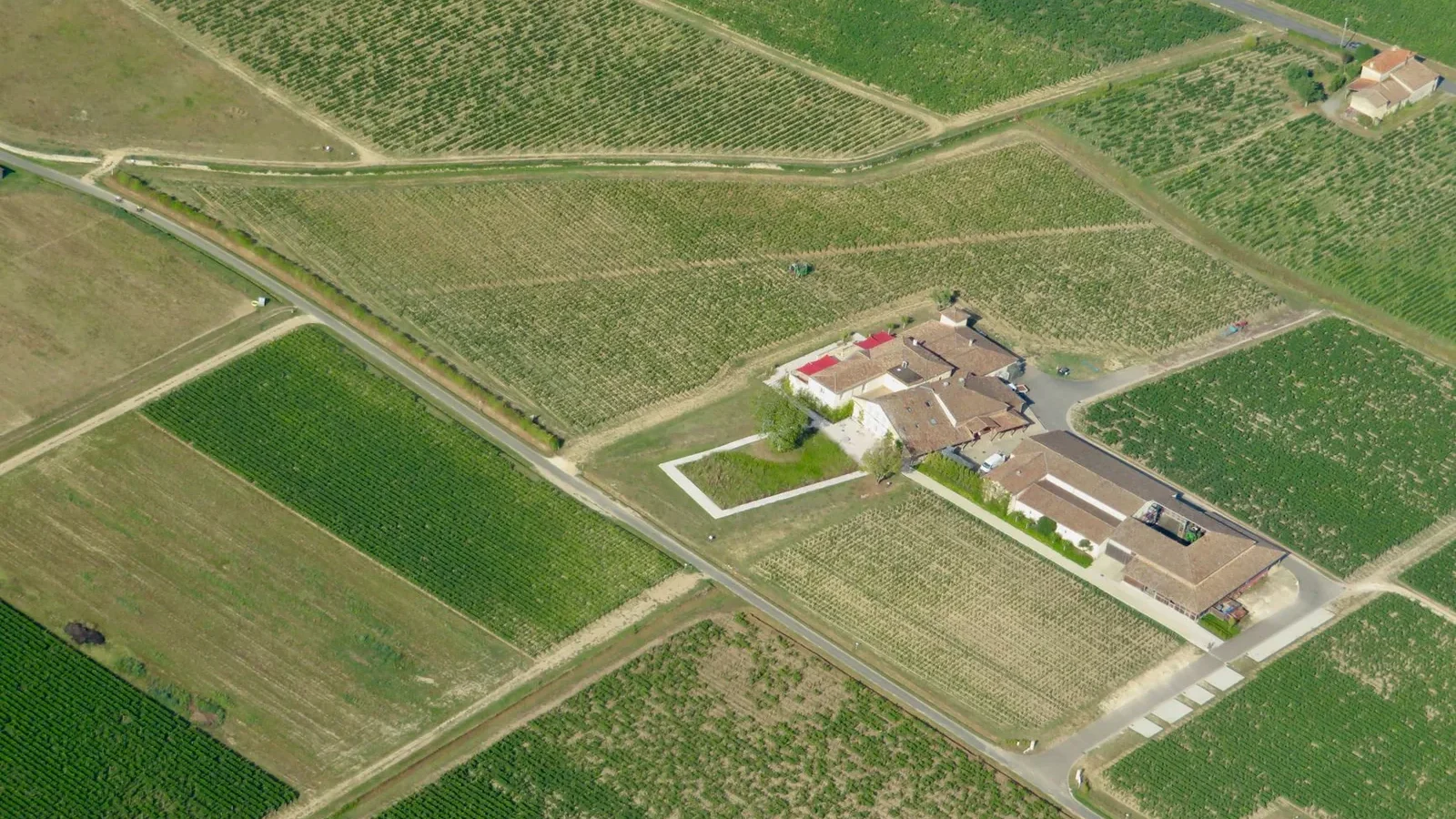 Expansive farmland and farmhouses under a clear sky
