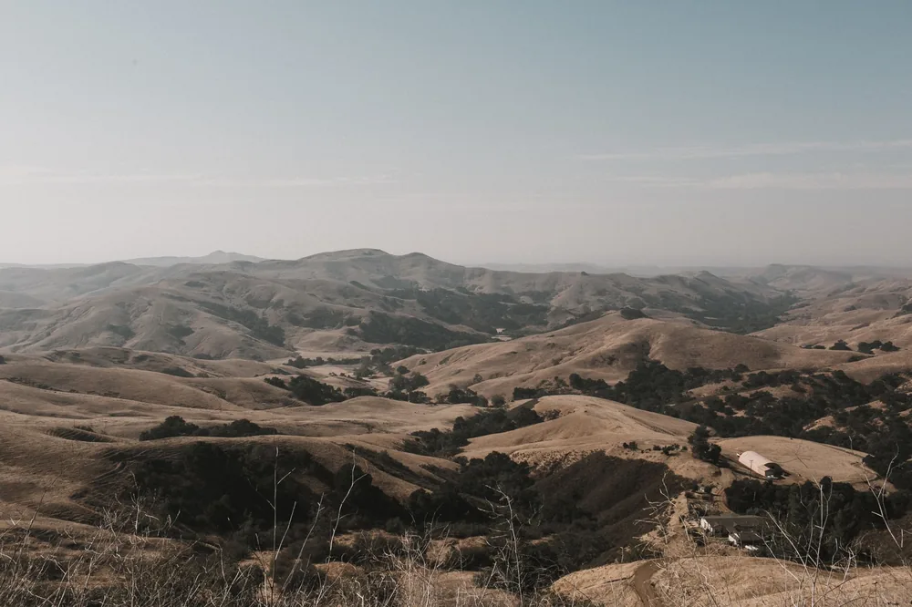 Expansive view of California's rolling hills and open sky, captured at dusk, showcasing natural beauty
