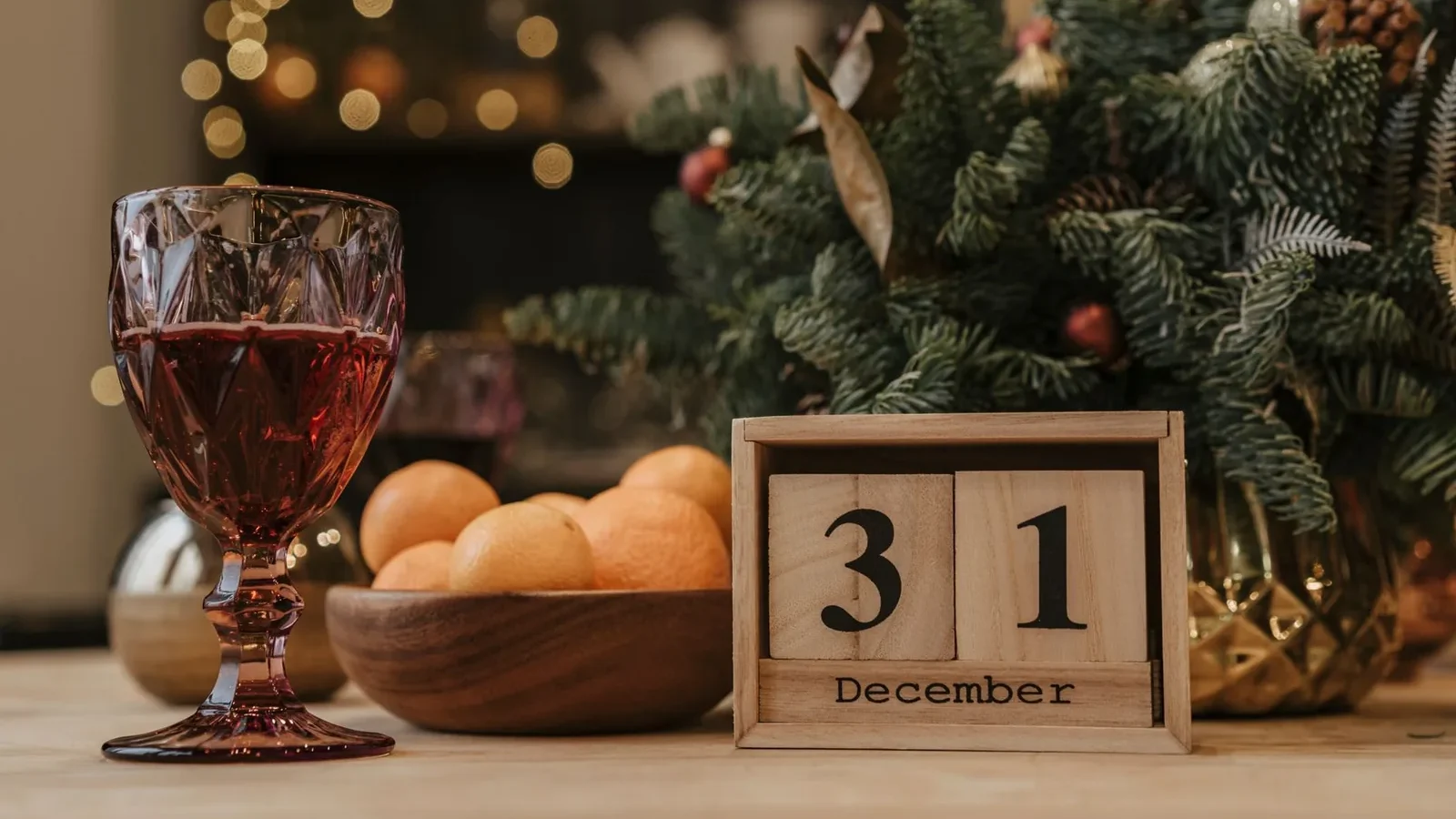Festive New Year's Eve scene with a glass of red wine, December 31 calendar, and holiday decor