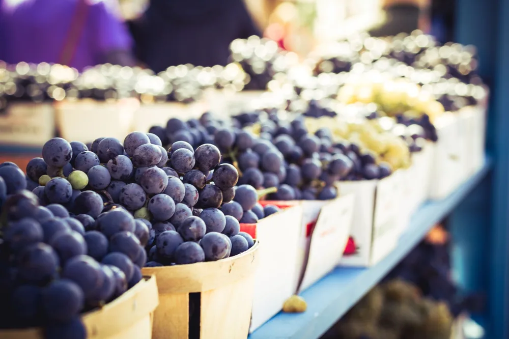 Fresh grapes on display in wooden baskets at a local open-air market